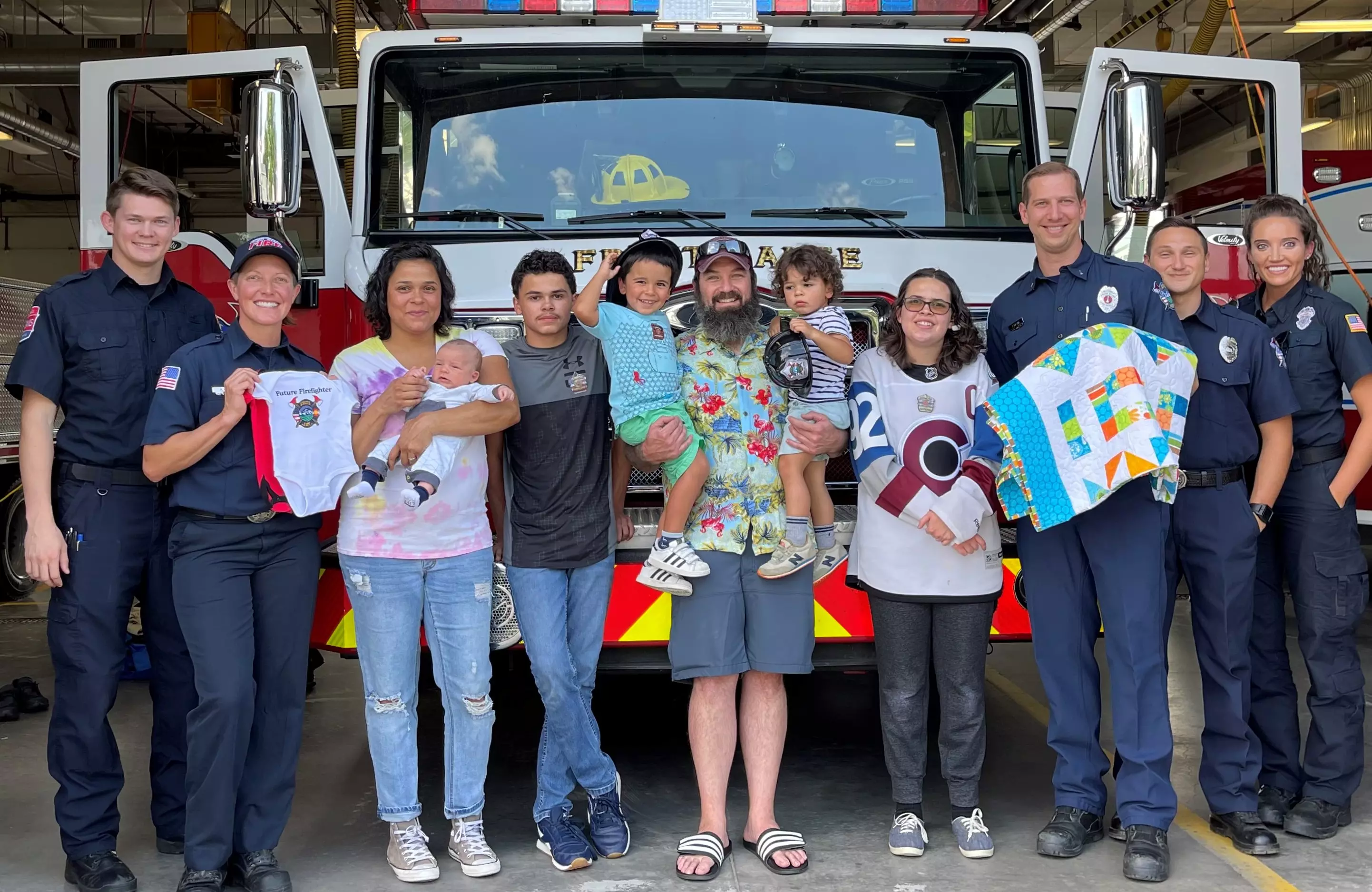 Firefighters and EMS crew with family and baby